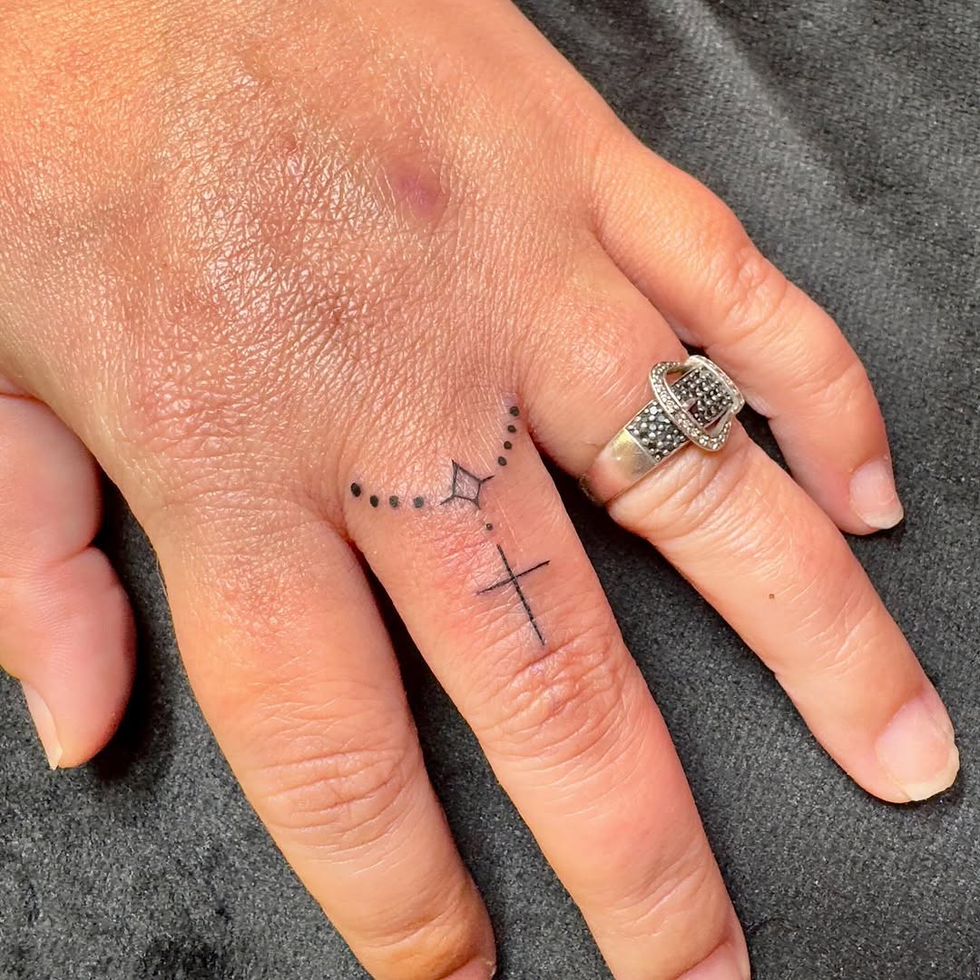 Dainty fine-line cross tattoo